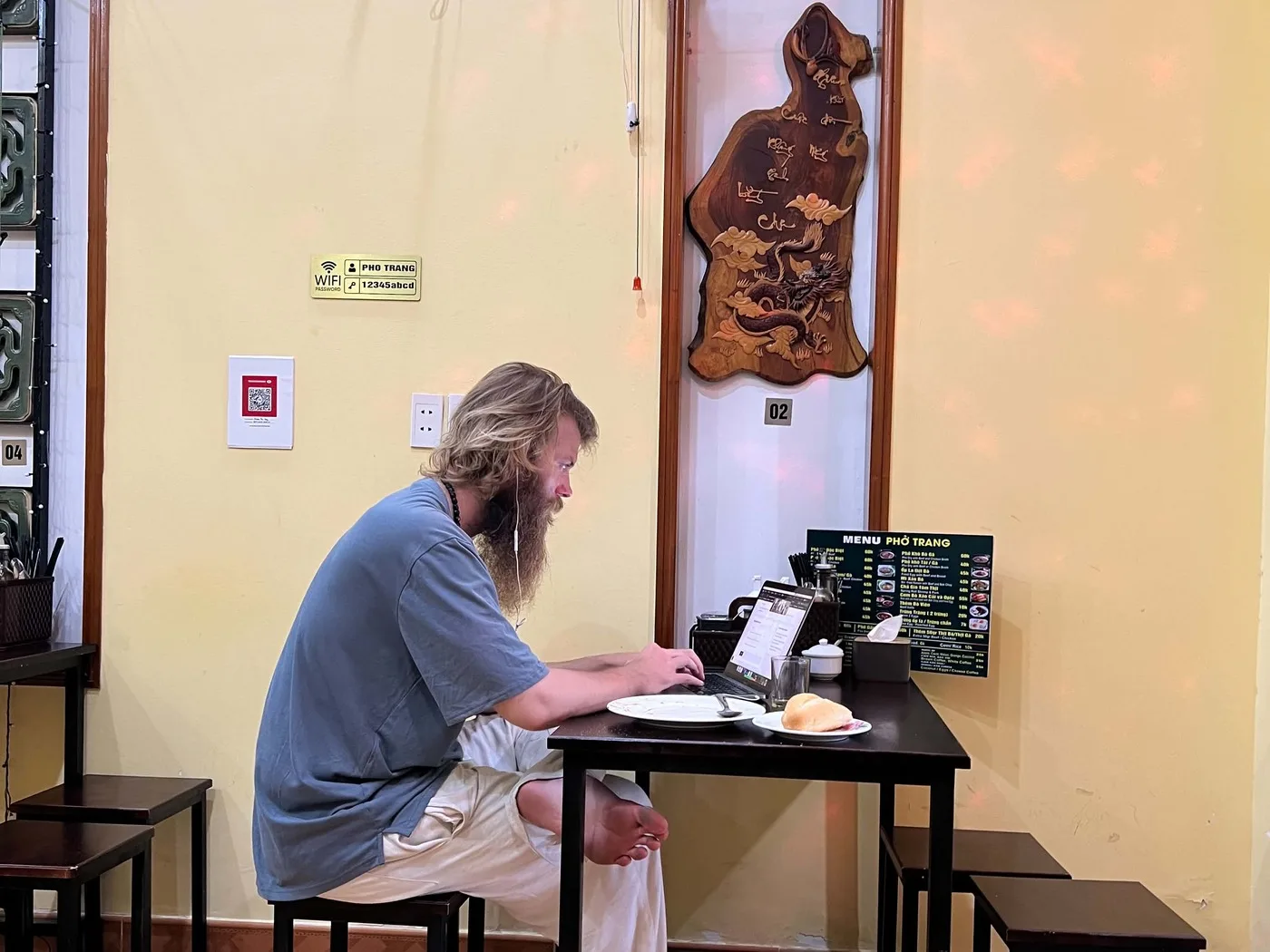 Rick at a pho shop table with a laptop